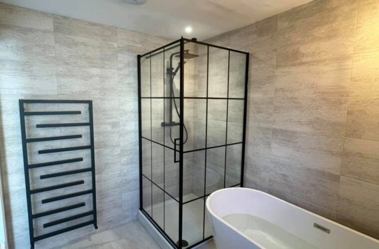 Modern bathroom with a black-framed walk-in shower enclosure, complete with a rainfall shower system and minimalist black fixtures.